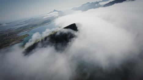 cinematic fpv drone shot stabilized from lofoten flying towards a cloud covered peak in norway