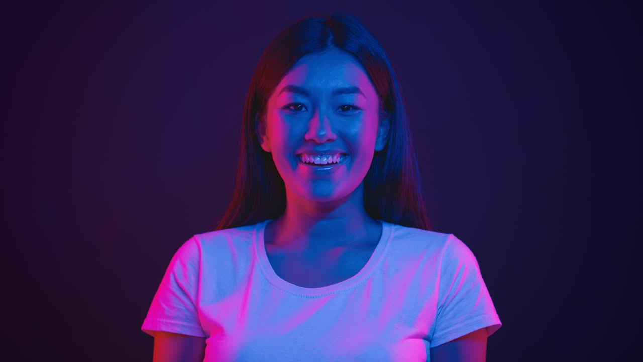 Donna sorridente alla luce del neon