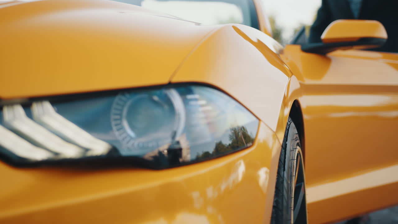 밝은 노란색 컨버터블 스포츠카를 운전하는 남자