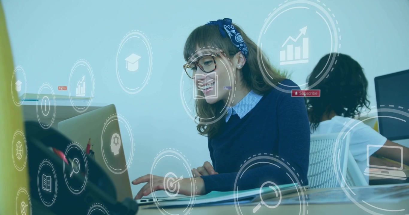 Donna d'ufficio che accende il laptop a una parete divisoria gialla, evocando icone mentre digita contenuti di marketing.
