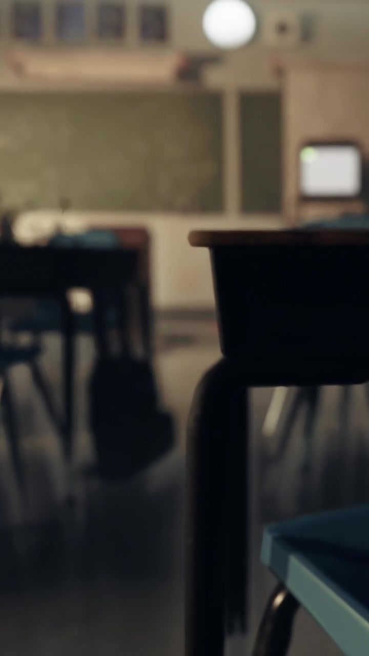 Empty classroom with desks and chalkboard in the background during school hours