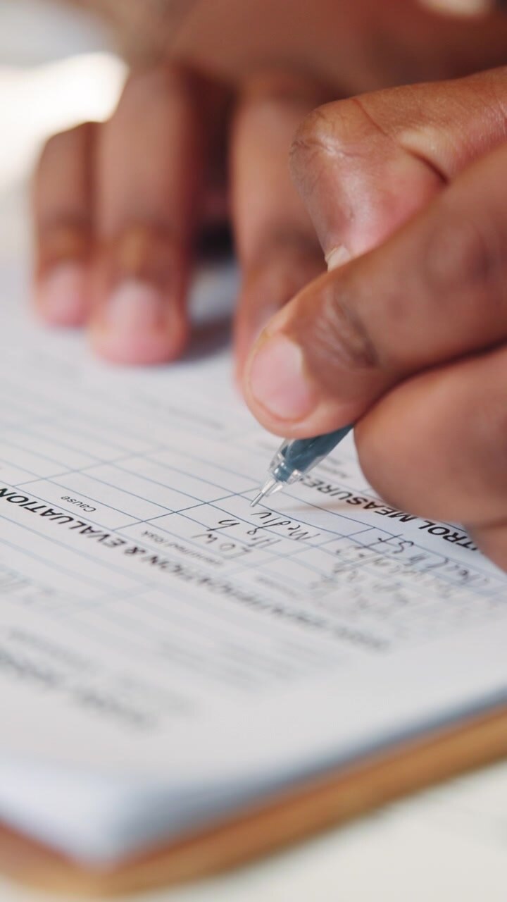 Person Filling Out Risk Assessment Form on Clipboard