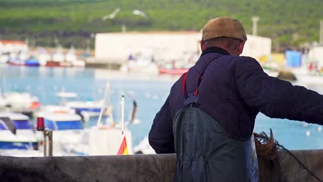 hand-held shot of a fisherman pulling up his nets in puerto barbate