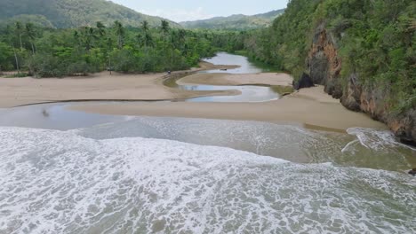 aerial flight showing river río san juan flowing into caribbean sea in samana