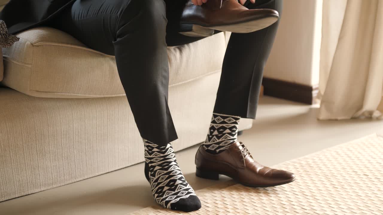 Man putting on dress shoes with suit on
