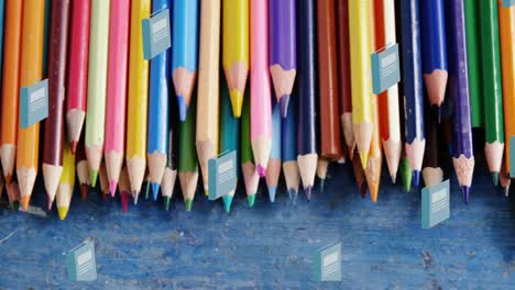 animation of blue schoolbooks moving over coloured pencils on school desk