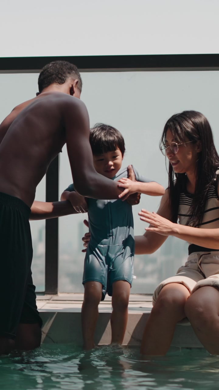 Young Parents Helping Their Son Enter a Rooftop Swimming Pool