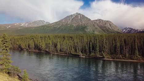 Schöner-Rundflug-Entlang-Des-Takhini-Flusses-Mit-Grünen-Waldbäumen-Und-Bergen-Im-Hintergrund-An-Einem-Sonnigen-Tag,-Yukon,-Kanada,-Overhead-Antenne-Seitlich