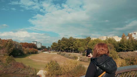 Chica-Usando-Teléfono-Y-Tomando-Fotos-Del-Parque-Por-La-Mañana,-Montpellier---Francia