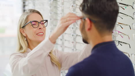 óptico-Ayudando-A-Un-Cliente-A-Elegir-Gafas-Durante