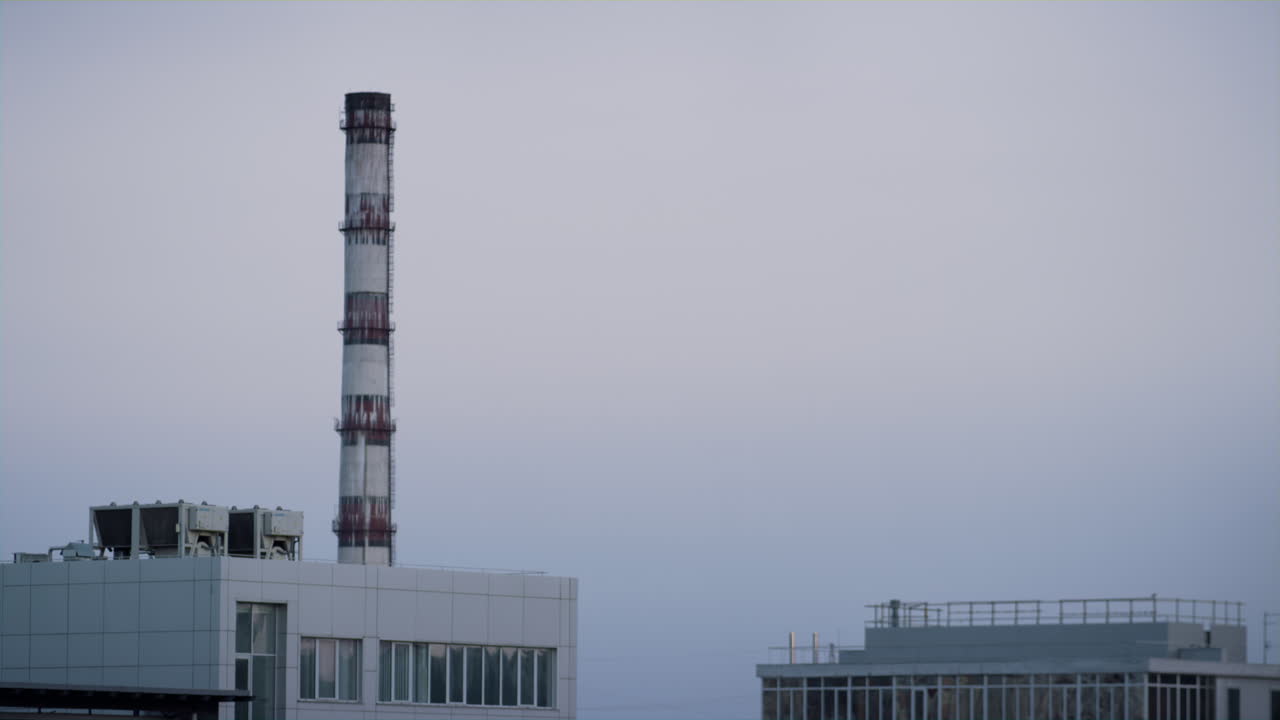 torre de la fábrica de tuberías en la zona industrial de la ciudad violeta hora de la noche disparo de avión no tripulado.
