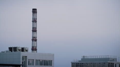 factory pipe tower in city industrial zone purple evening time drone shot.