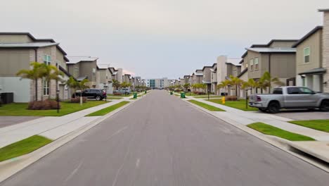 a drone shot going through the middle of a street in melbourne florida with buildings on both sides of it