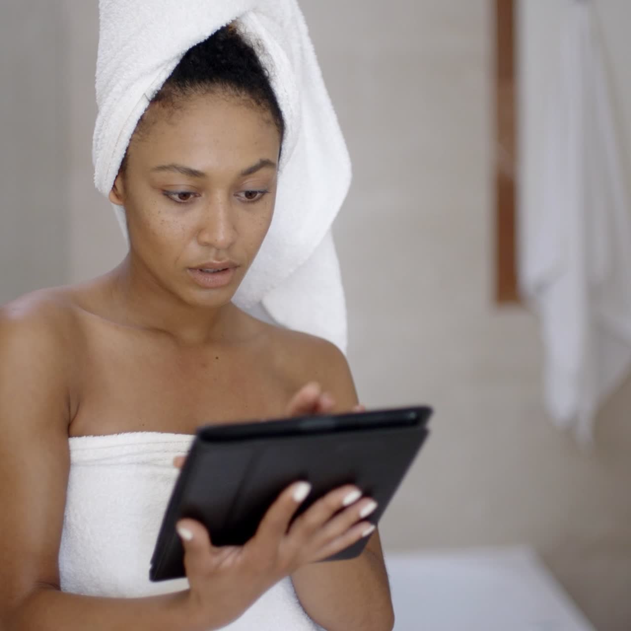Giovane donna con asciugamano da bagno che usa un tablet