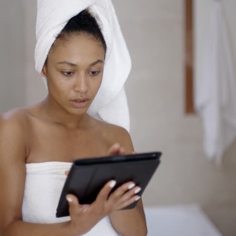 Young-Woman-Wearing-Bath-Towel-Using-Tablet-Computer