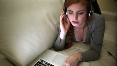 Beautiful-brunette-listening-to-music-lying-on-bed