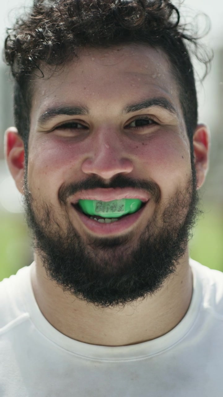 Ritratto di un Atleta Sorridente con Paradenti Verde