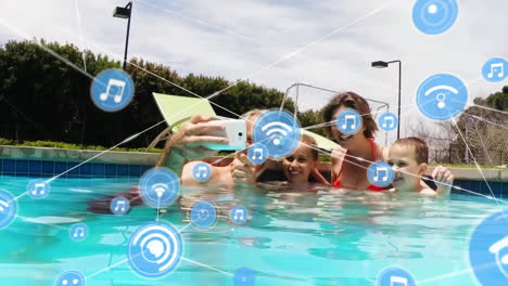 animation of network of digital icons against caucasian family taking a selfie in the pool