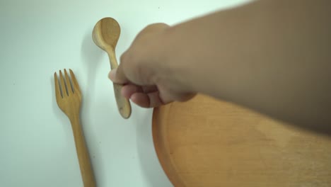 galleta de navidad sobre el plato de madera, tenedor y cuchara con fondo blanco.