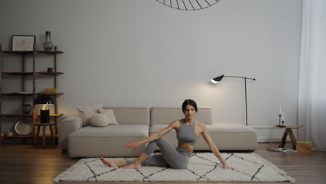 mujer practicando posturas de yoga en casa