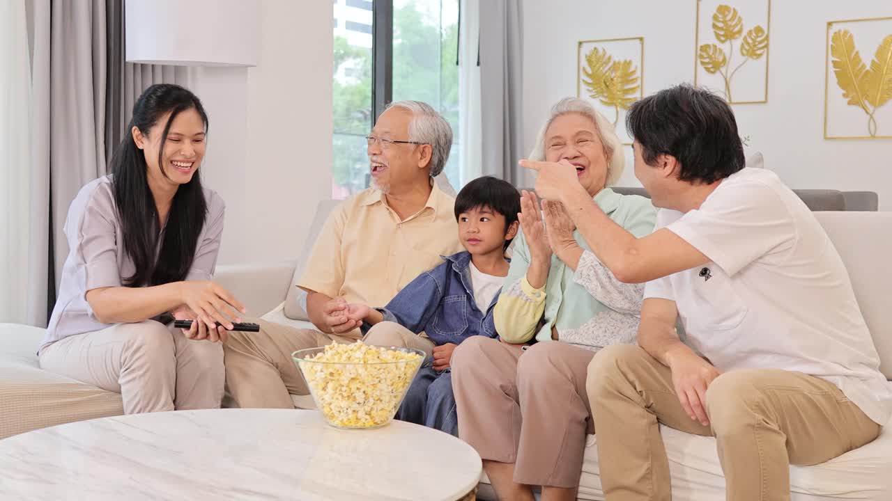 A joyful family shares popcorn on a sofa, creating a warm, relaxed atmosphere with natural lighting and cheerful interactions