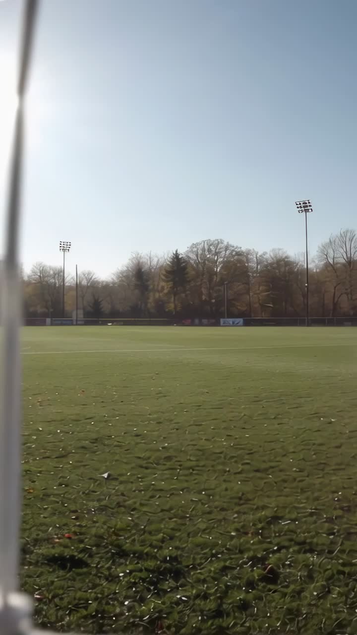 Vídeo vertical: Câmera fazendo panorâmica e inclinação, rede em primeiro plano, sol criando reflexo para esportes