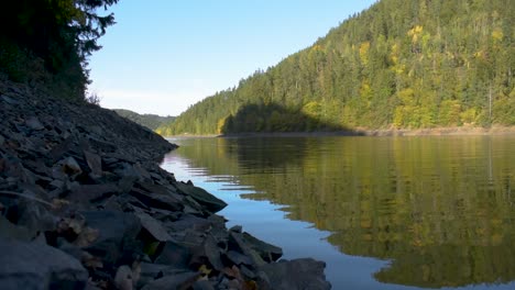 beautiful view of a big lake with reflection on the water and mountains in the background in autumn