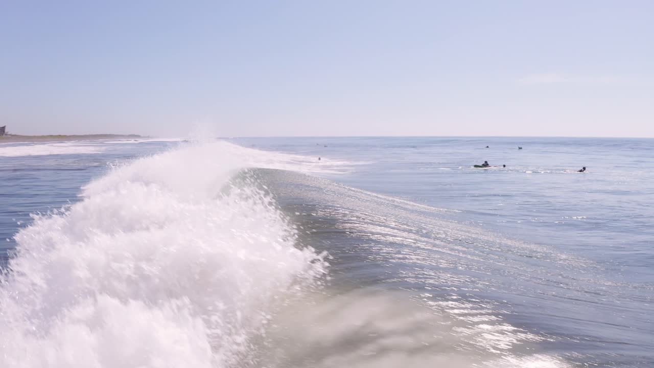 반짝이는 물 위에서 빠른 파도 초저비행을 하는 서퍼 공중