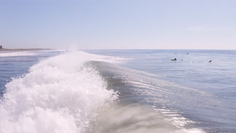 surfer-aerial-grabbing-a-quick-wave-super-low-flight-above-sparkling-water