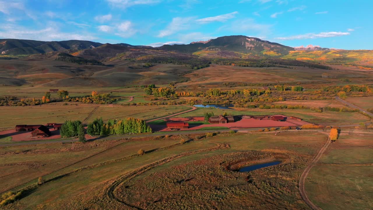 Scenic Fall autumn drive Mill Creek Ranch farm land Ohio Creek Valley Pass near Crested Butte Colorado Gunnison Country aerial drone Mill Castle rock landmark feature colorful Aspen trees pan right