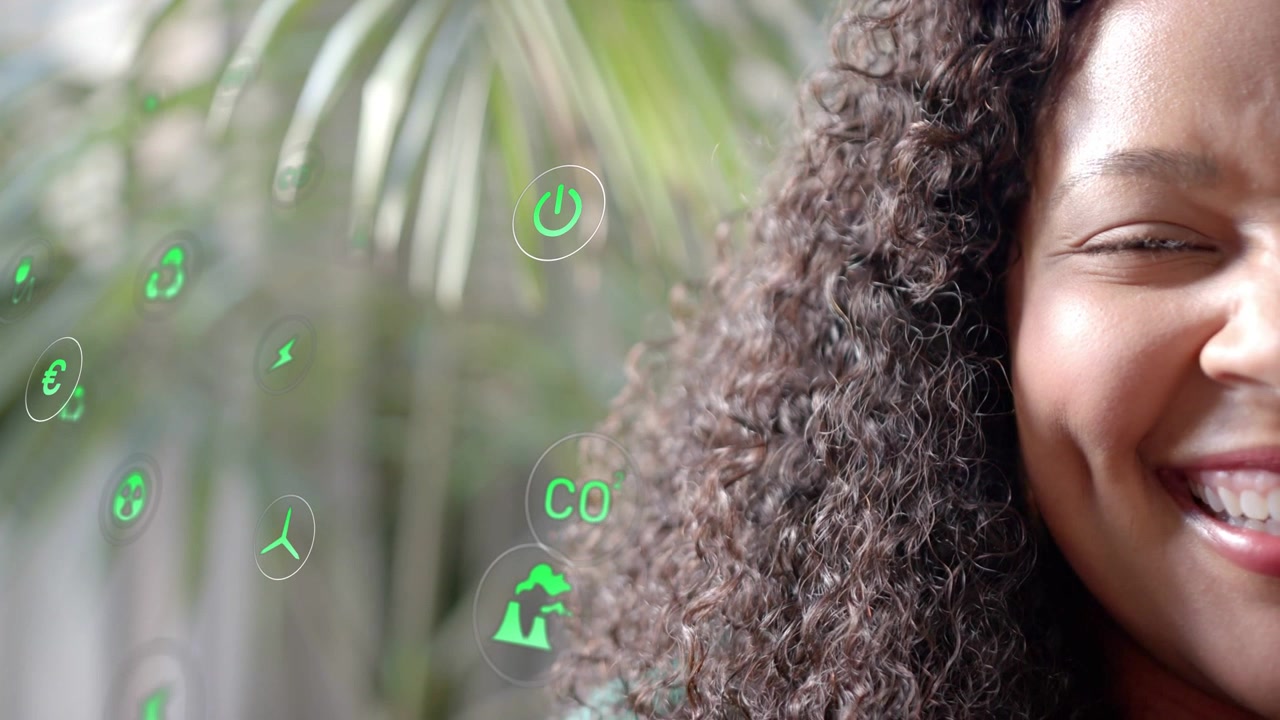 All'inizio del clip, primo piano di modella sorridente, icone di energia verde che fluttuano, attraversando i capelli, mostrando temi ecologici.
