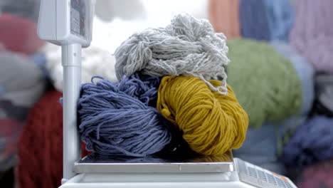 woman weighs colorful wool thread