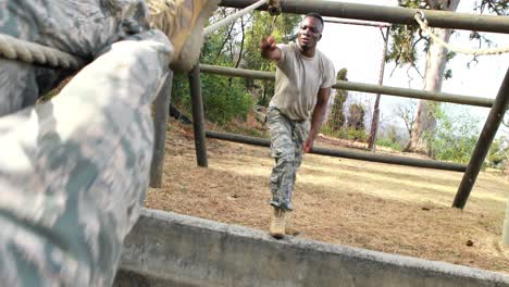 soldado militar subiendo la cuerda durante un curso de obstáculos