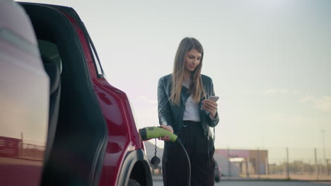 mujer cargando un vehículo eléctrico