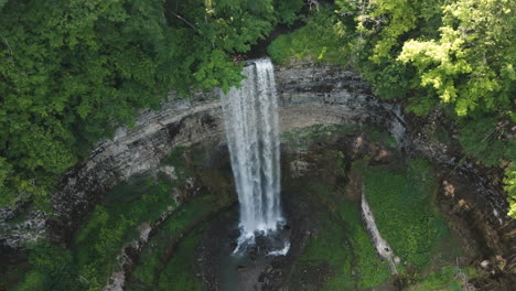 Las-Mariposas-Vuelan-Delante-Mientras-El-Dron-Desciende-Sobre-Las-Cataratas-Tew,-Ontario,-Canadá