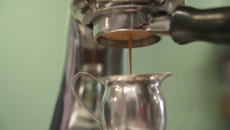 low angle upward view of coffee dripping through portafilter espresso machine