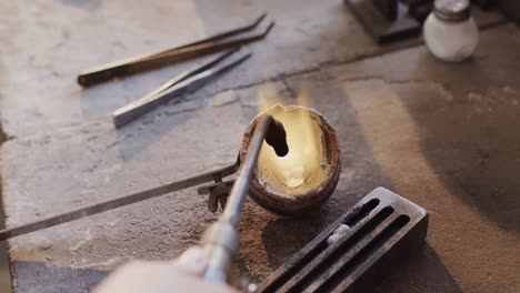 close up of melting metal with blowtorch in workshop in slow motion