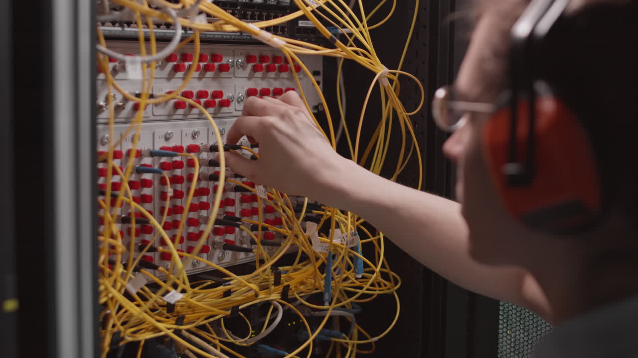 Technician working on fiber optic cables in a server room