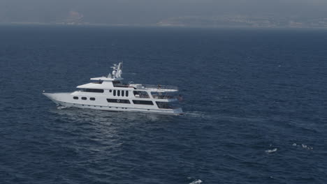 Aerial-zoom-out-drone-shot-of-yacht-sailing-in-the-deep-blue-sea