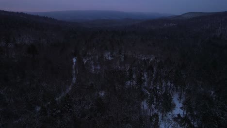 aerial drone video footage of nightfall in the snowy appalachian mountains during winter, in the catskill mountains sub-range