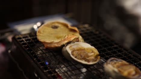 scallops and crab shells cooking on a grill