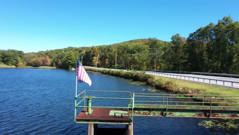 american flag waving on lakeshore bridge near coastal road