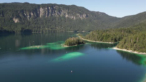 unique holiday summer location with gigantic rocky mountains hills covered by nature flora great lake covering the space with bits of shiny stones bits under the water tourists traveling on boats here