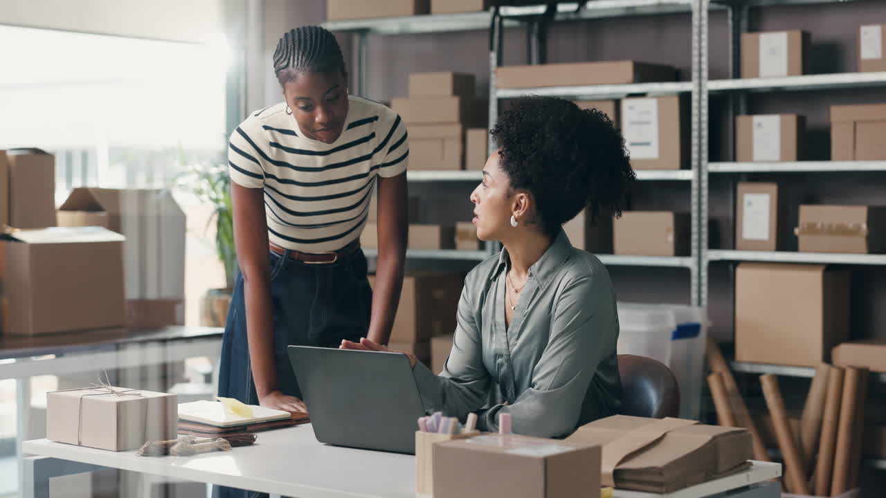 Due donne che collaborano al laptop in un ufficio di magazzino e-commerce
