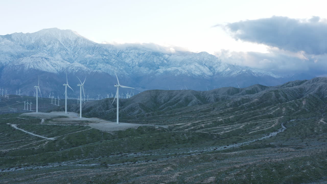 바람 터빈의 공중 느린 팬 뒤에 큰 눈  ⁇ 인 산과 함께