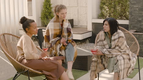 un buen grupo multicultural de tres amigas hablando y bebiendo vino