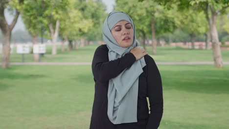 sick muslim woman suffering from neck pain in park