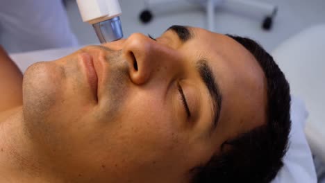 Doctor-performing-laser-hair-removal-on-patient-face