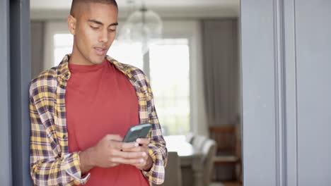 happy biracial man using smartphone at home, slow motion