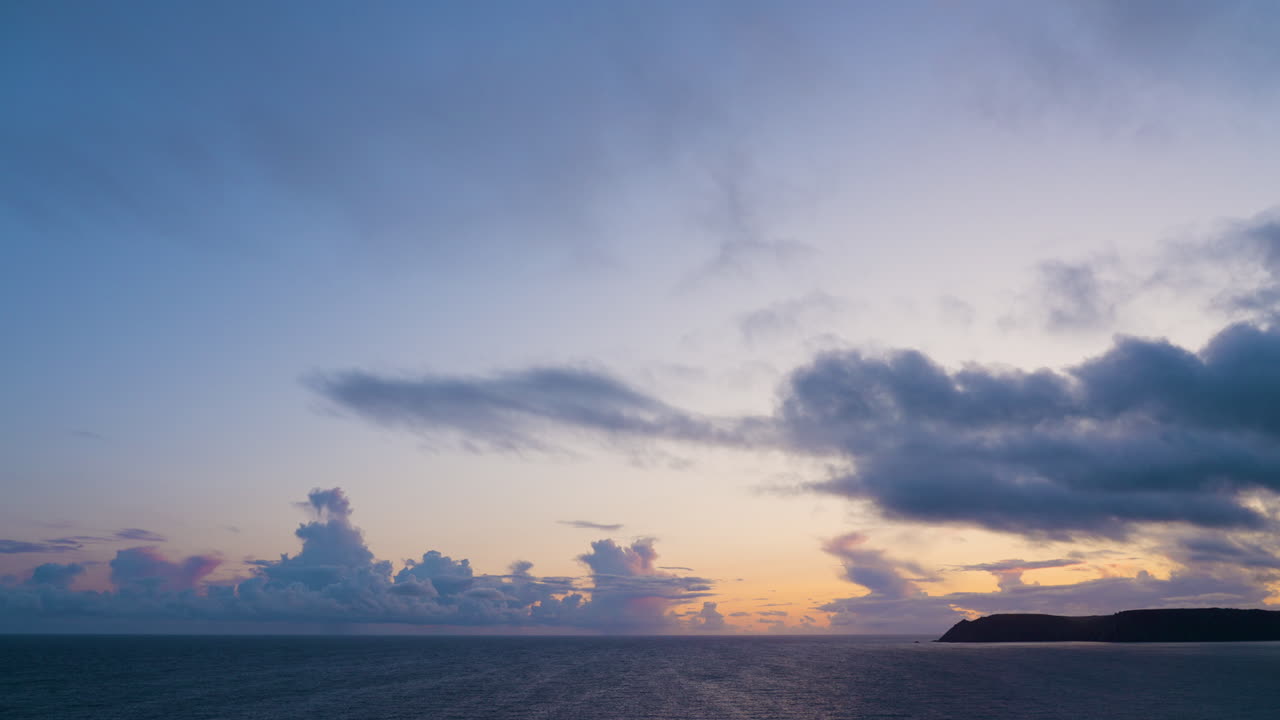 극적인 구름과 함께 바다 위에 해가 지는 것